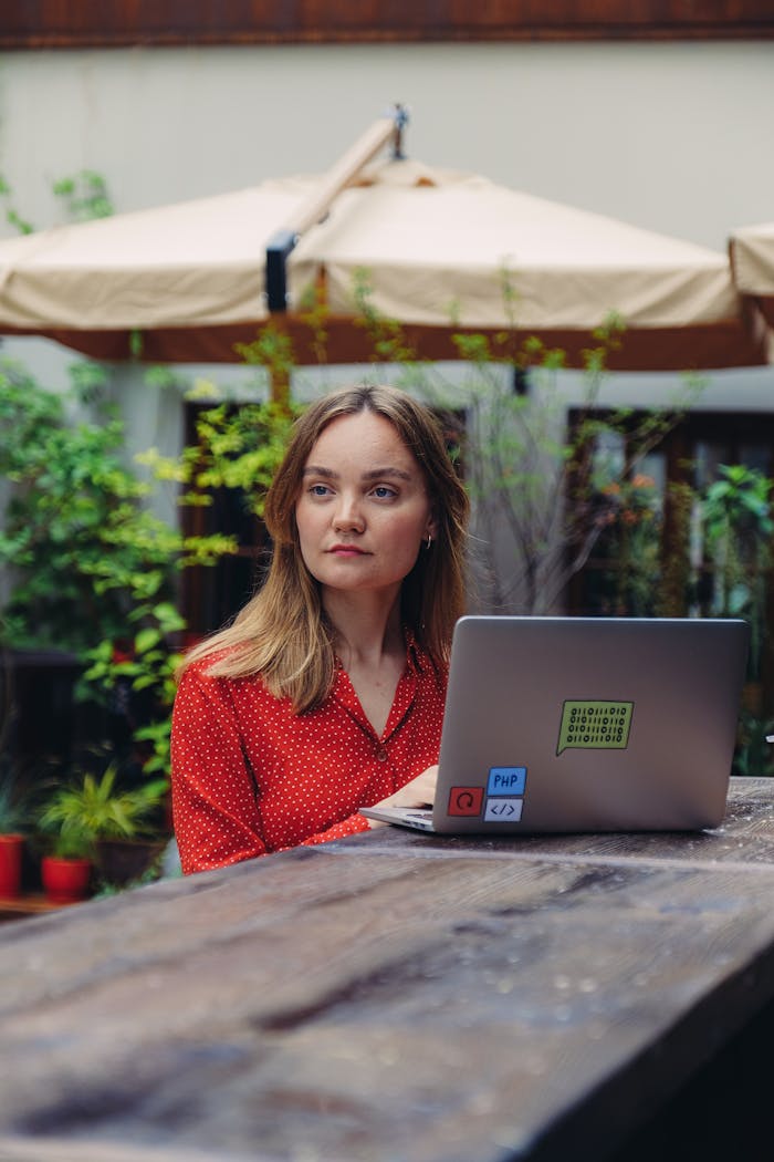 gallery-6 Female freelancer working on a laptop outdoors in a casual setting during summer.