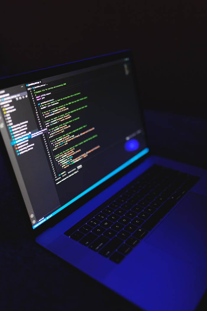 about-img A laptop showcasing colorful code in a dark environment, ideal for tech or programming content.